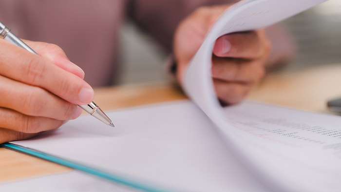 Person goes through paper and is writing something