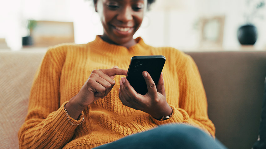 Perosn smiling while touching a smartphone with finger